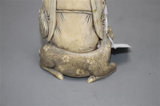 A Chinese carved ivory group of a sage holding a peach, seated beside a crane and a deer, 17cm